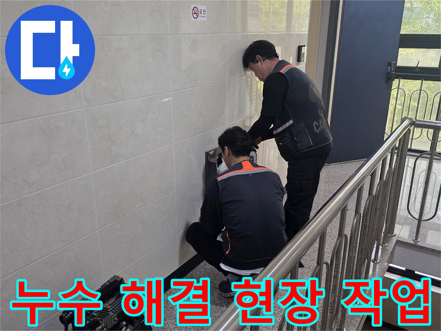두 명의 전문 기술자가 건물 벽면의 누수 의심 지점을 정밀하게 탐지하며 신속하고 확실한 문제 해결을 위한 준비를 하고 있습니다.