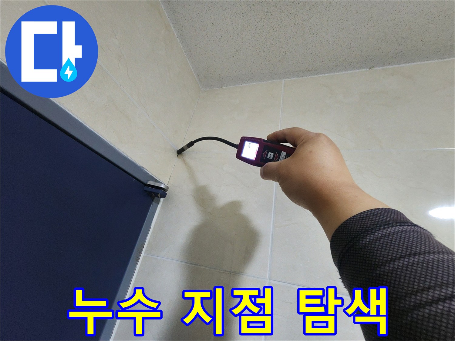 숙련된 누수 엔지니어가-정밀 탐지 장비를 이용해-벽면 타일의 숨겨진 누수 지점을-꼼꼼하게 탐색하고 있습니다.
