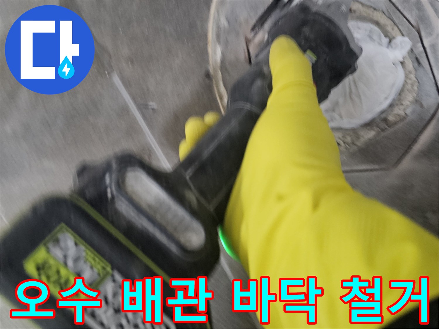 노란색 보호 장갑을 착용한-작업자가-전동 공구를 이용해-오수 배관 주변의-굳은 타일을-조심스럽게 철거하는 모습입니다.