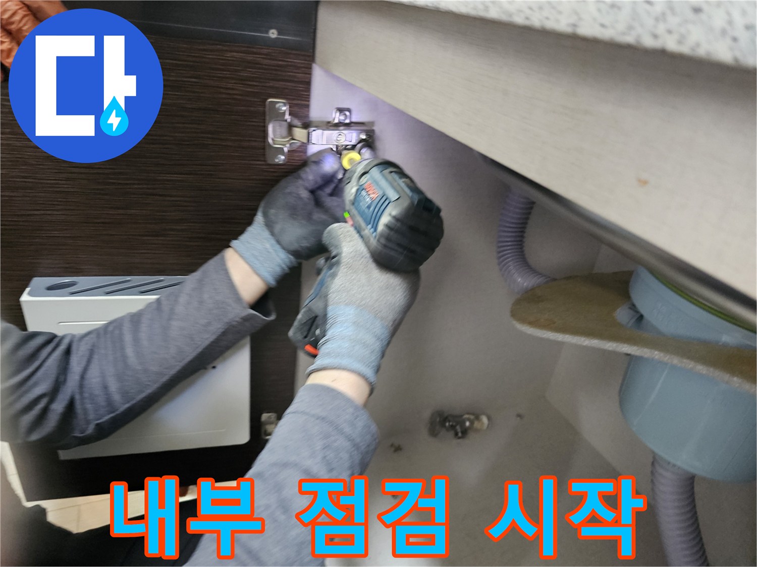누수 엔지니어가-싱크대 누수-내부 점검을-시작하기 위해-하부장 패널을-분리하는-장면