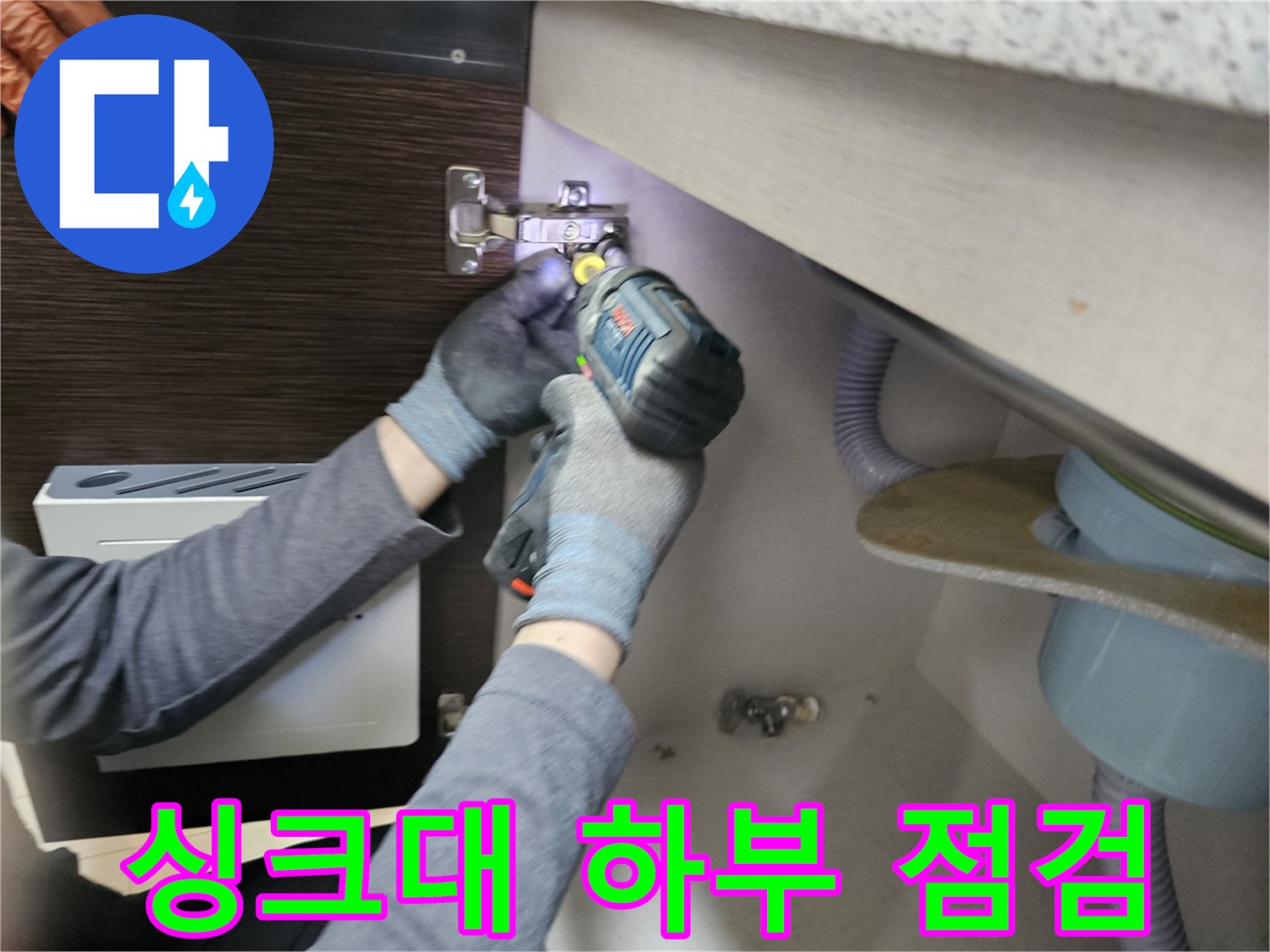 누수 전문가가-싱크대 하부를-점검하기 위해-패널을-분리하는-모습