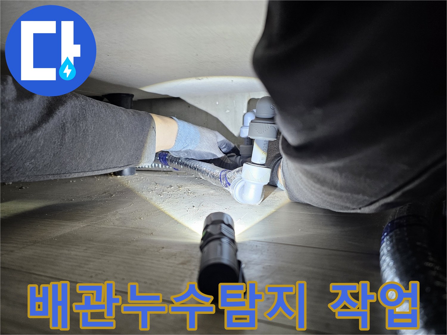 누수-탐지-전문가가-어두운-공간에서-배관-연결부를-확인하는-모습