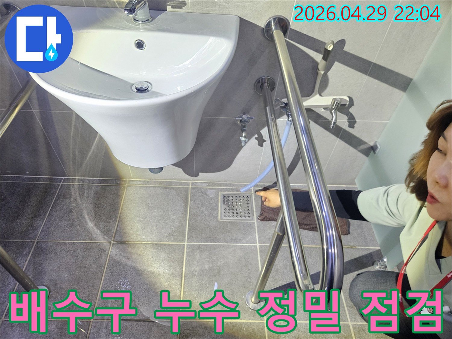 누수 전문 기술자가 화장실 바닥 배수구 주변의-누수 여부를-정밀하게 점검하고 있습니다.
