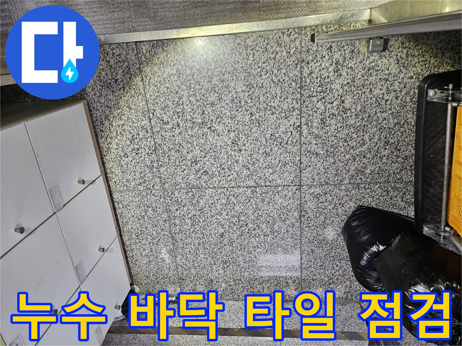 포천 아파트의 바닥 타일에서-누수로 인한 물기 흔적을 발견하고-정확한 누수 지점을 찾기 위한-전문가의 면밀한 점검이 이루어지고 있습니다