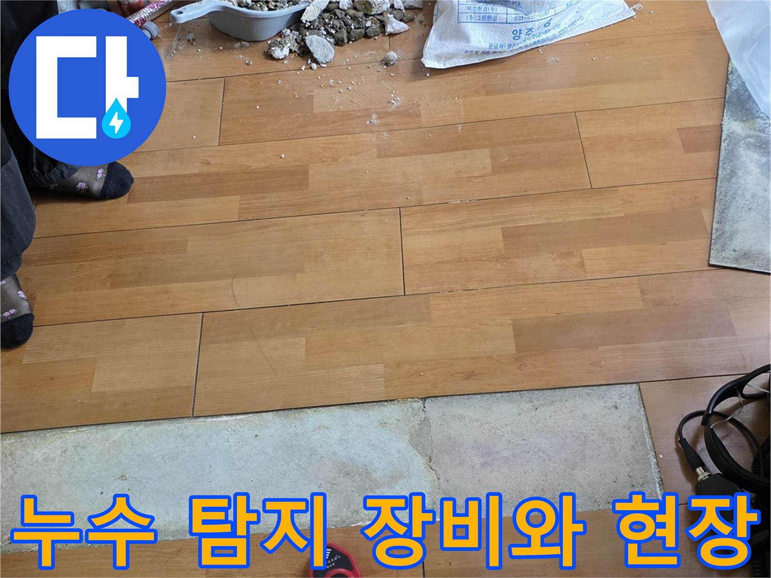 누수 지점을 찾기 위해 사용된 가스 탐지기와 작업 중인 거실 바닥 전경입니다.