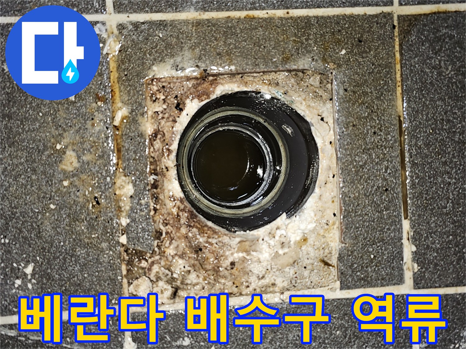 베란다 배수구에서-오수가 역류하여 바닥에 고여있는-심각한 배관 막힘 현장을 보여주는 사진입니다.