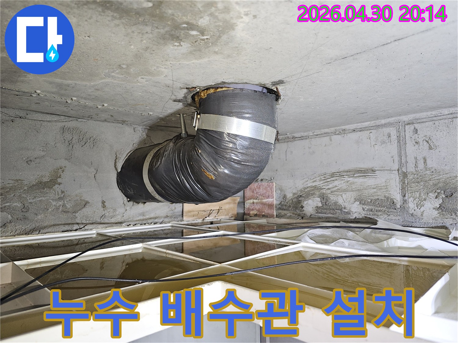 아파트 누수 현장에서-물을 안전하게 배수하기 위해-설치된 임시 배수관의 모습입니다.