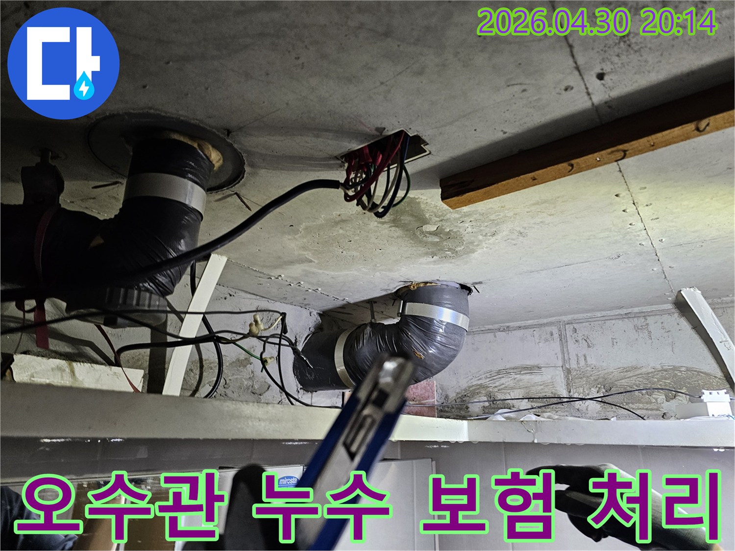 천장 아래-오수관 배관의-누수 현장을-보험 처리를 위해-꼼꼼히 기록하고-점검하는 모습입니다.
