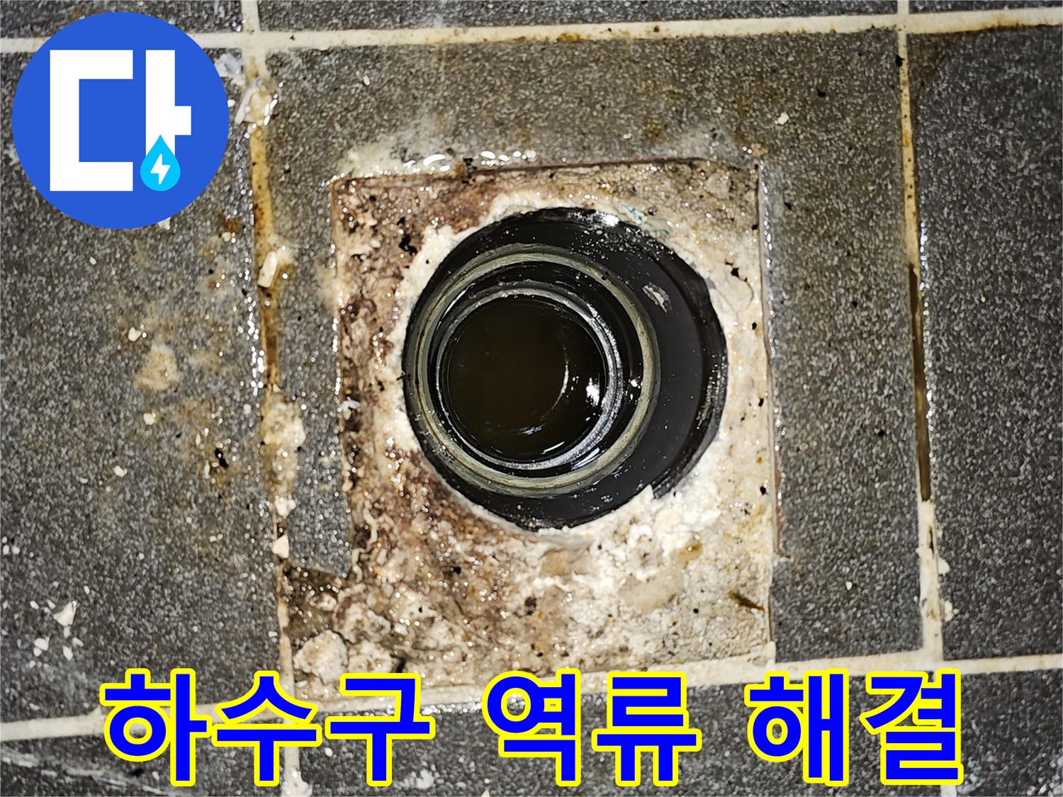 하수구에서 물이 역류하여-바닥에 고여있는 모습을 보여주는-심각한 배관 막힘 현장의 사진입니다.
