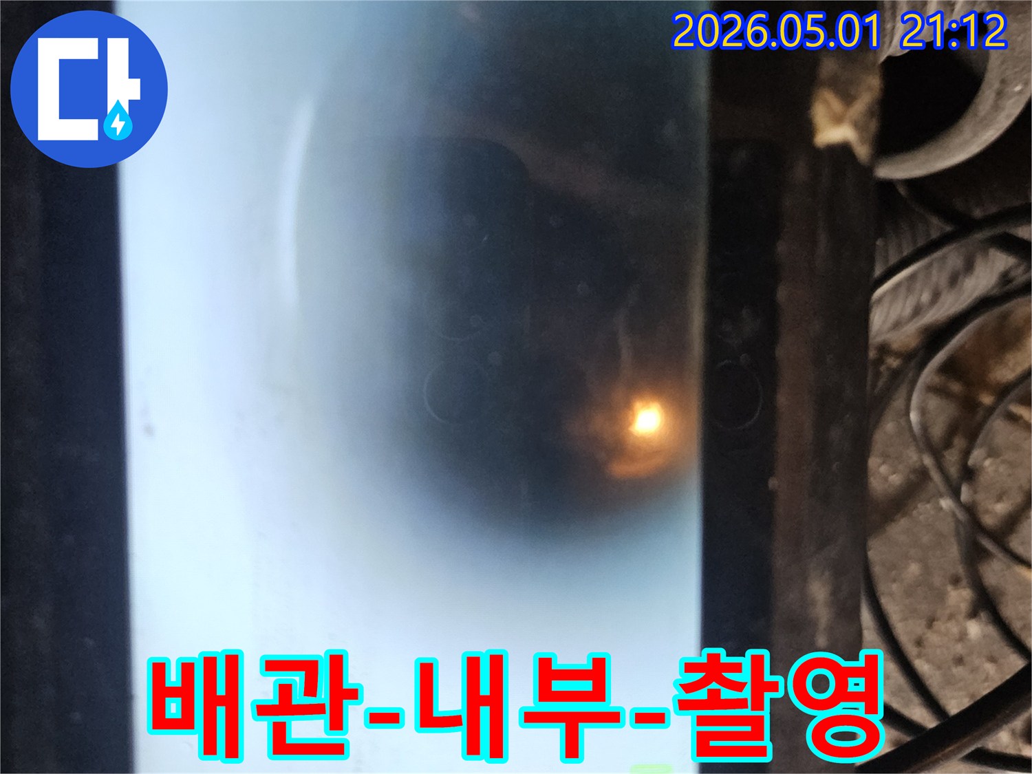 누수 탐지 작업 중 배관 카메라로 촬영된 내부 모습입니다-어두운 배관 속을 밝게 비추는 조명과 함께-배관의 상태를 실시간으로 확인하고 있습니다