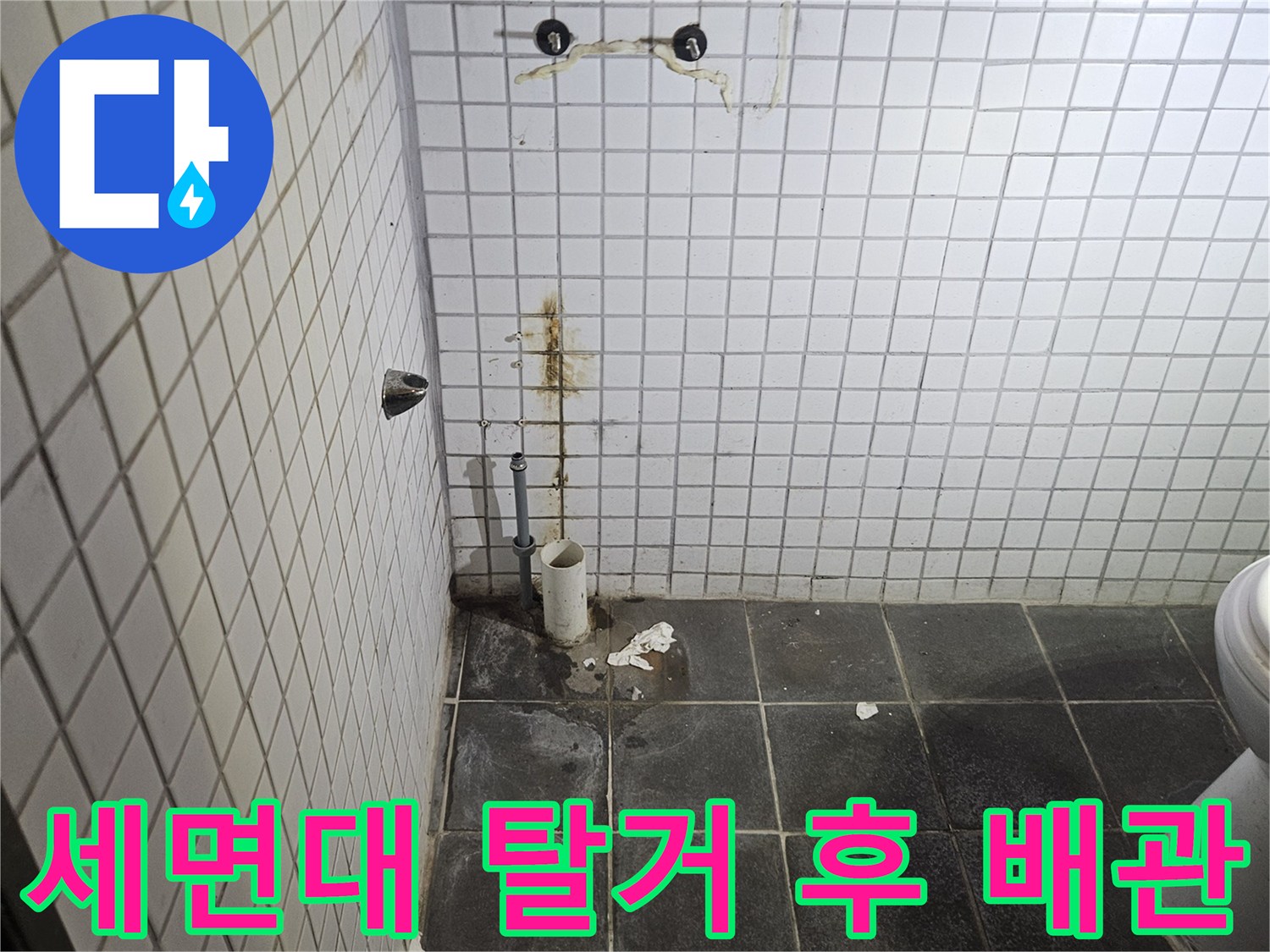 세면대 탈거 작업 후-욕실 벽면과 바닥에-드러난 배관 연결부와-누수 흔적을-정밀하게 검사하는-누수 전문가