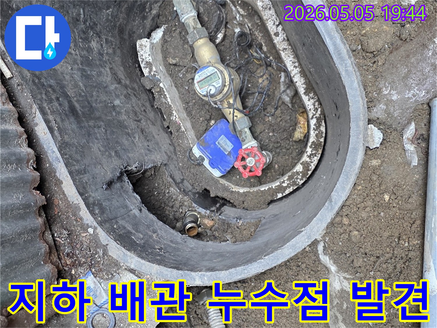 누수 탐지 전문가가 수도 계량기 주변의 물샘 현장을 면밀히 확인하고 있는 사진입니다.