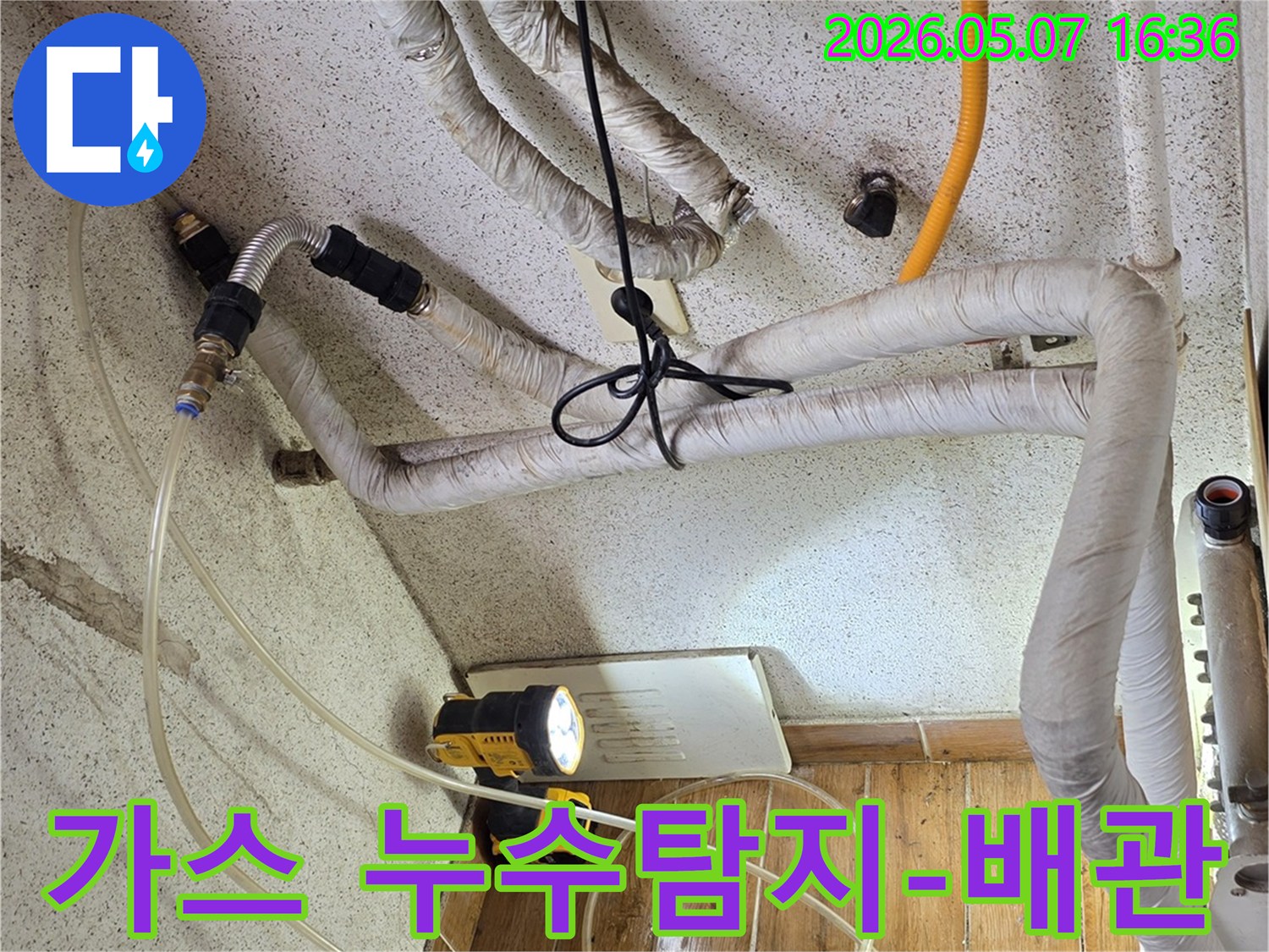 누수 전문가가-가스식 탐지 장비를 사용하여-배관의 미세한 누수 지점을 찾아내고 있습니다