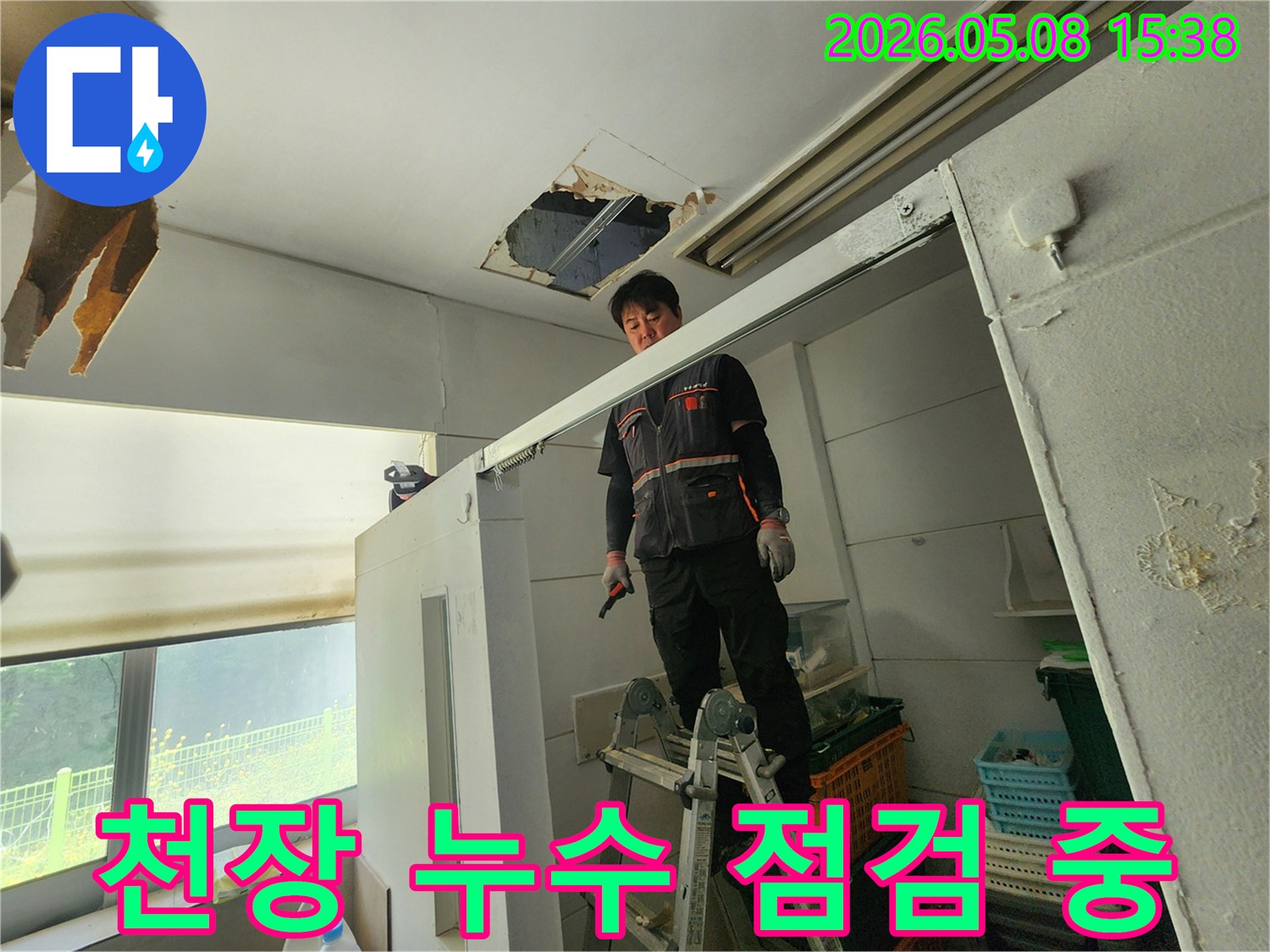 누수 전문가가 사다리 위에서-천장 누수 지점을-세밀하게 검사하고 있습니다