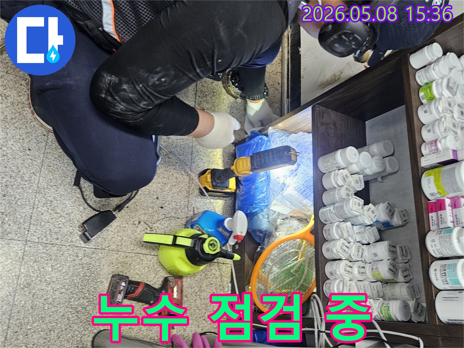 누수 점검 전문가가-헤드셋과 손전등을 이용해-좁고 어두운 공간에서-누수 여부를-확인하고 있습니다.