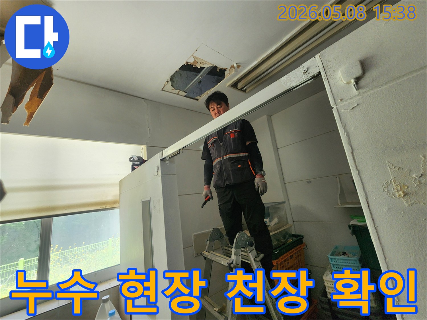 숙련된 엔지니어가 사다리를 딛고-천장 손상 부위를-면밀히 관찰하고 있습니다