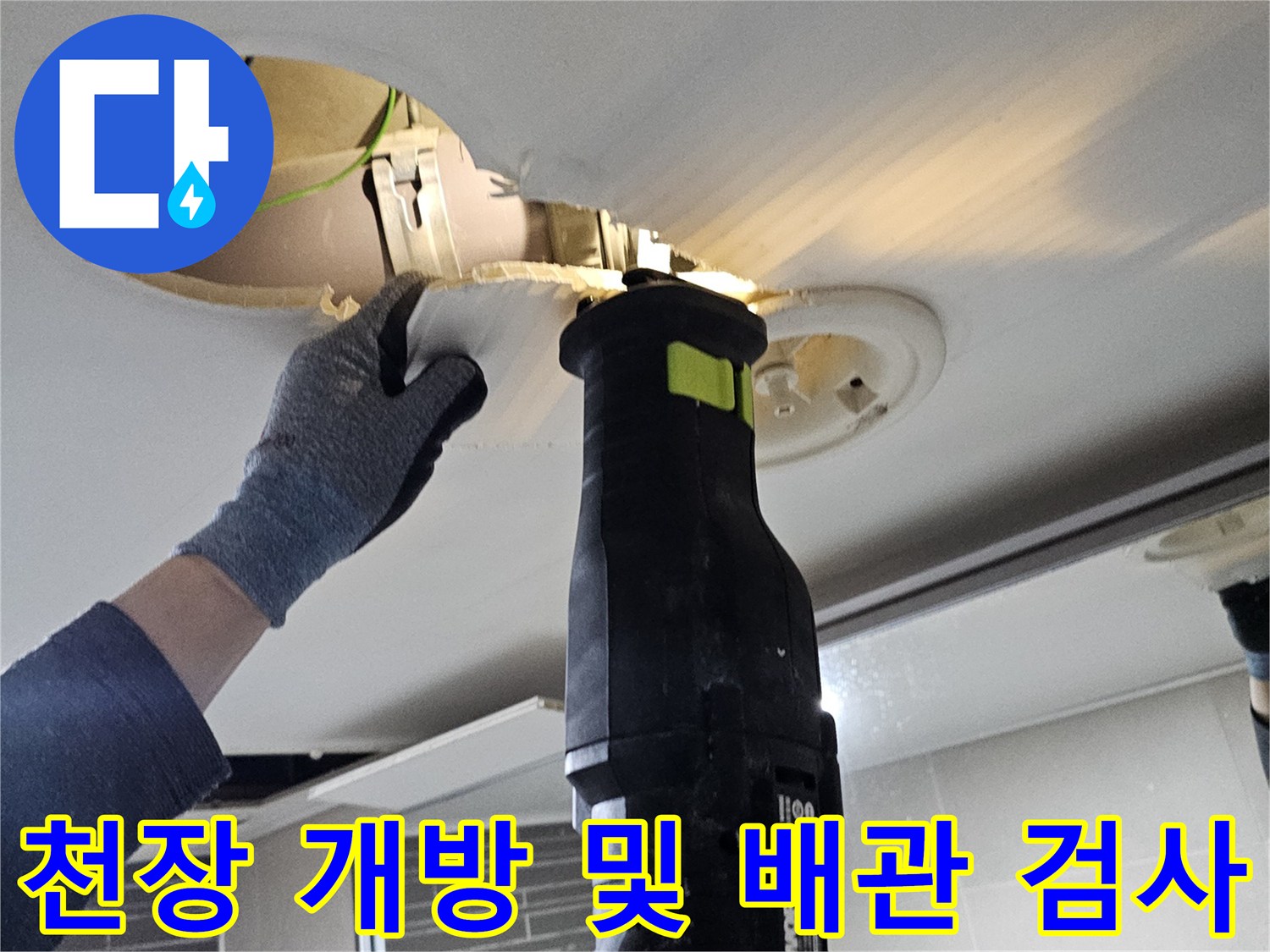 작업자가 천장 내부의 배관 상태를 점검하고 있는 장면