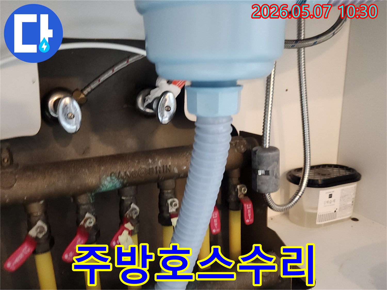 새로운 배수 호스가-싱크대 하부 배관에-안전하게 연결되어-누수 문제를-해결한 모습입니다.