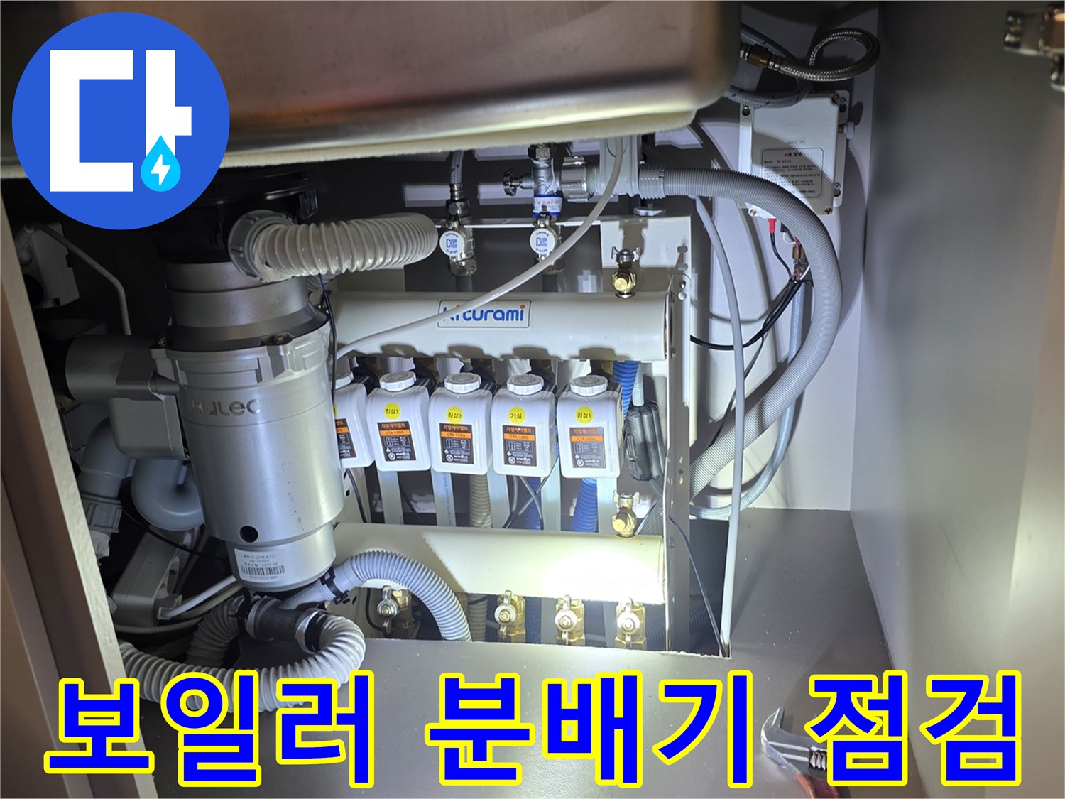 싱크대 하부장 내부의 보일러 분배기와 연결된 다양한 배관들
