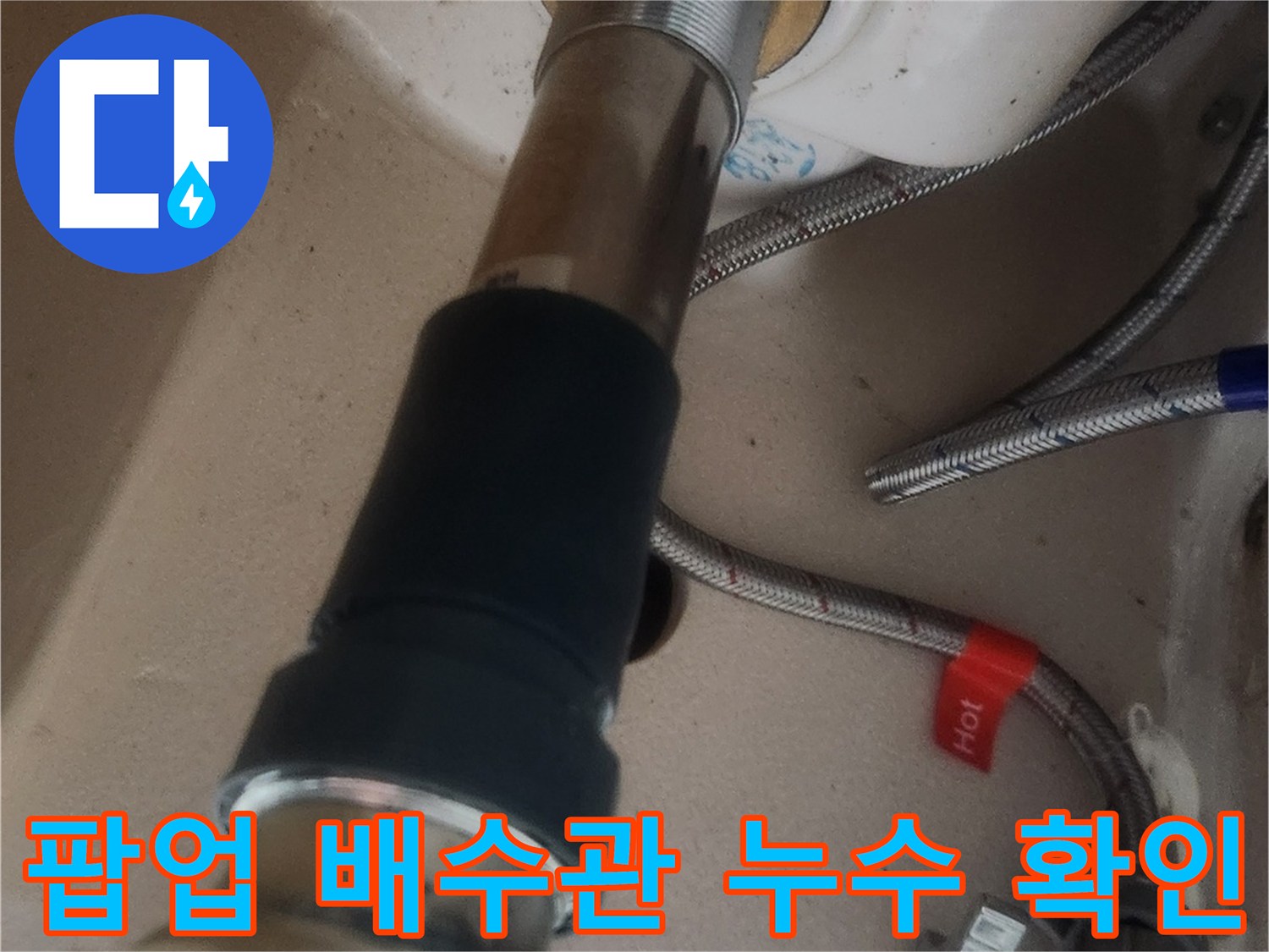 새로 교체된 세면대 팝업과 배수관의 연결 부위를 자세히 확인하며 누수 여부를 점검하는 모습