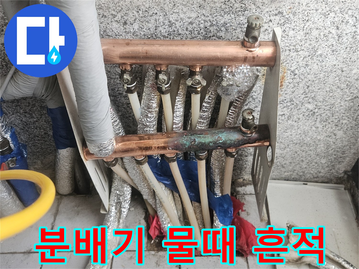 분배기 하단 배관 연결 부위의 누수 자국을 보여줍니다.