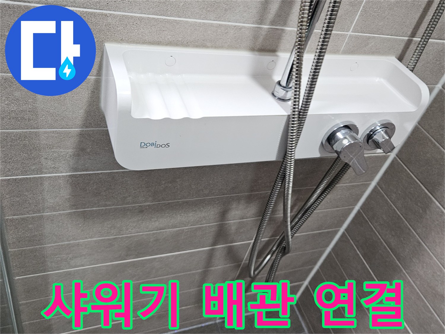 수전 하단에 연결된 샤워기 호스와 타일 벽면 사진