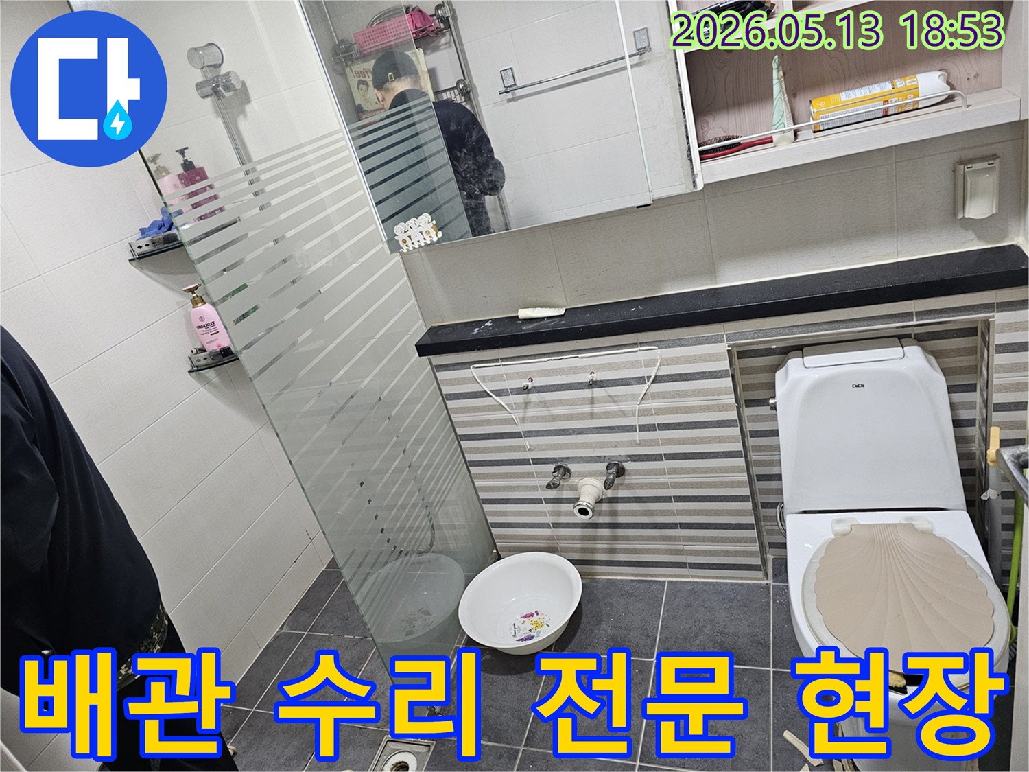 이 이미지는-인천 연수구 럭키송도아파트 화장실에서-배관 누수 수리 작업을 위해-세면대를 분리하고-배관을 점검하는 모습입니다.