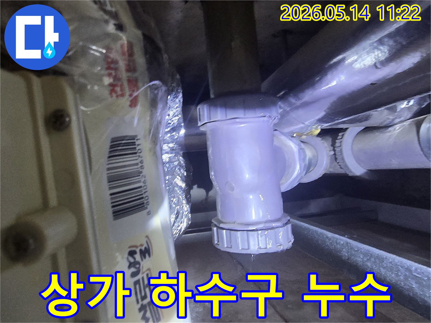상가 건물 하수구에서-물이 새는 현장을-전문가가 긴급히-점검하고 있는-사진입니다