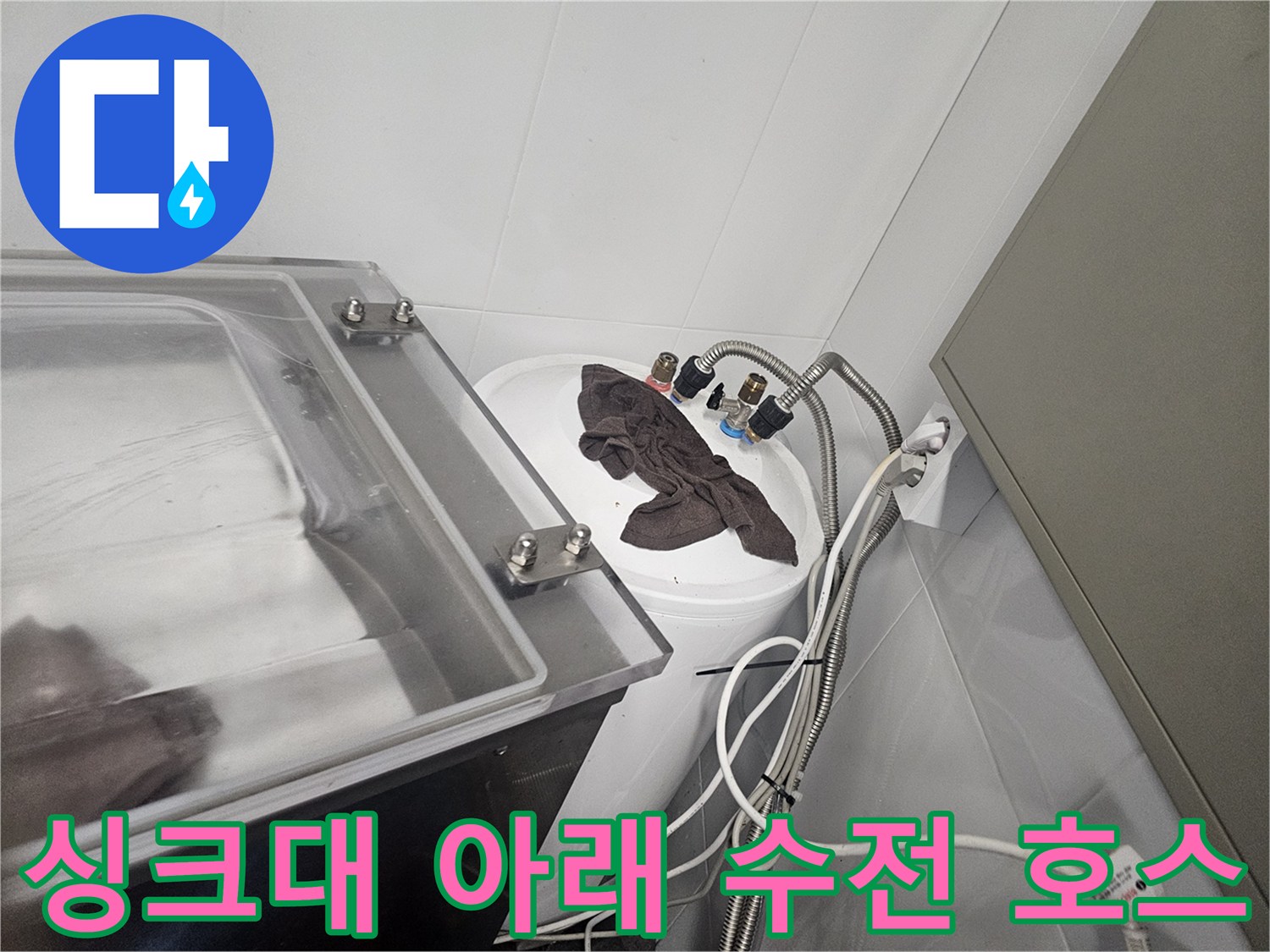 싱크대 하단에 위치한 수도꼭지 연결 호스와 밸브의 모습입니다.