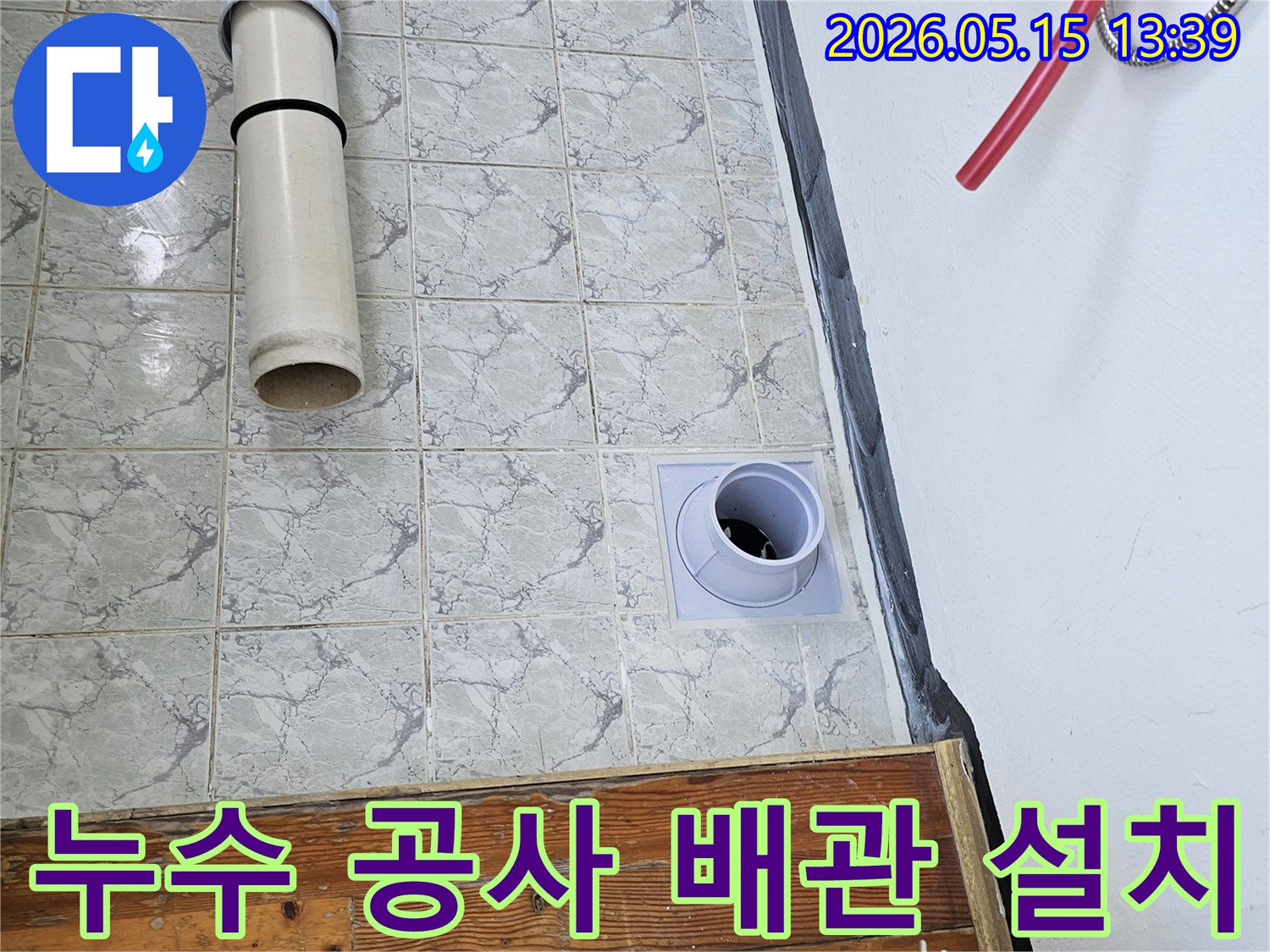 누수 공사 현장에서 배관 설치 작업이 진행되는 모습입니다-타일 벽면에 새로운 배관이 깔끔하게 시공되고 있습니다