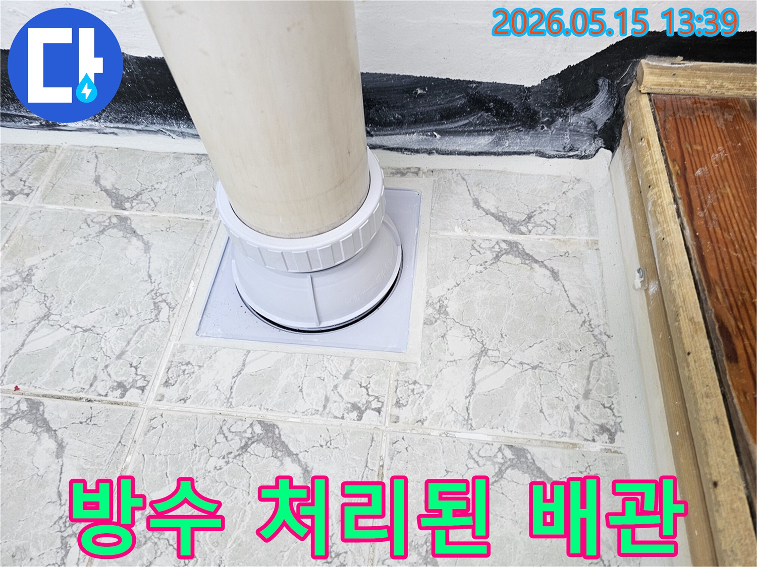 새롭게 설치된 배수관과-주변 바닥 타일-마감 상태를 보여주는-누수 공사 현장 이미지입니다