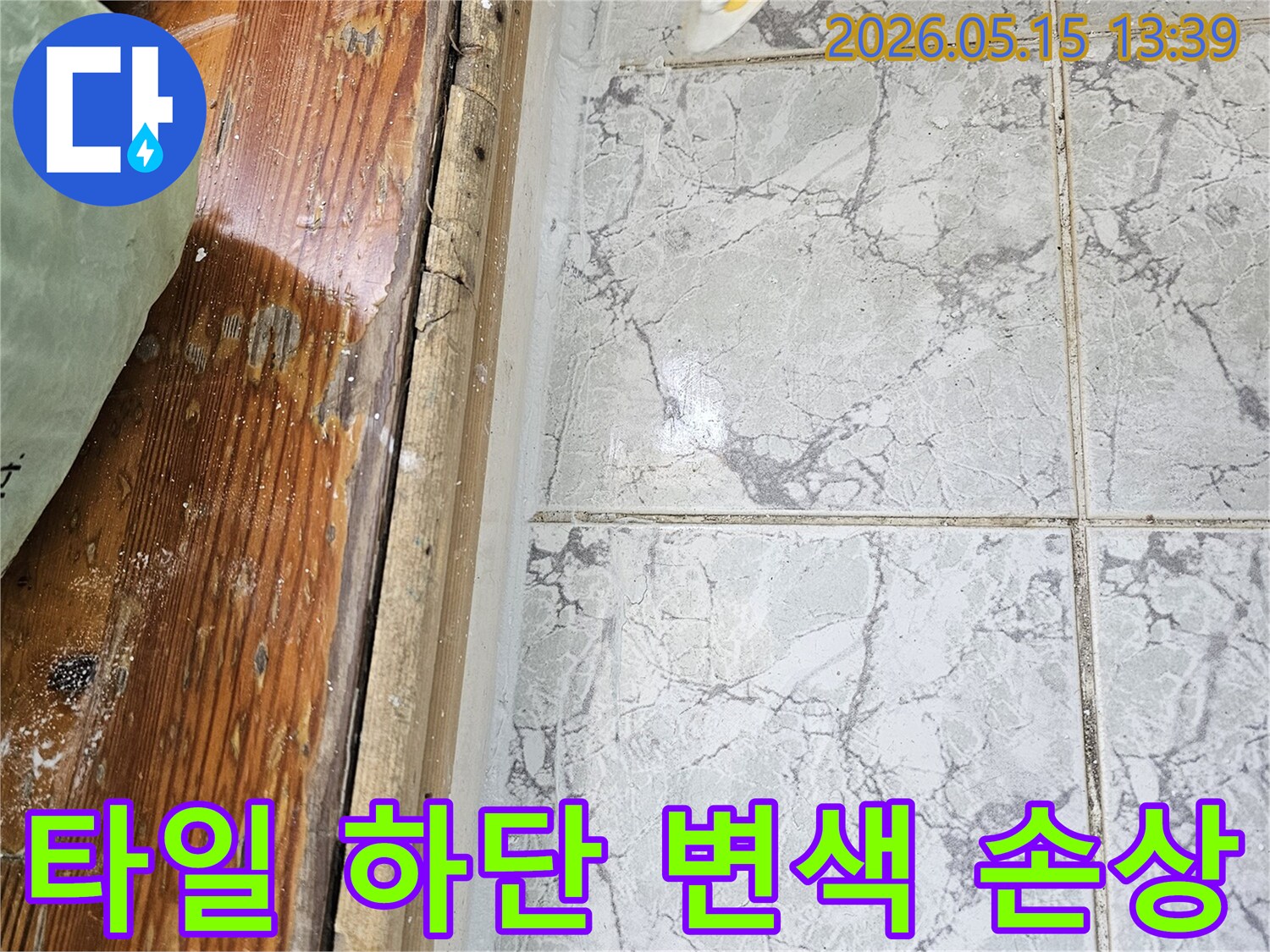 이 이미지는-의정부 신곡동 아파트에서 발생한-누수로 인해 타일 하단부가 변색되고-목재 마감재가 손상된 모습을 보여줍니다
