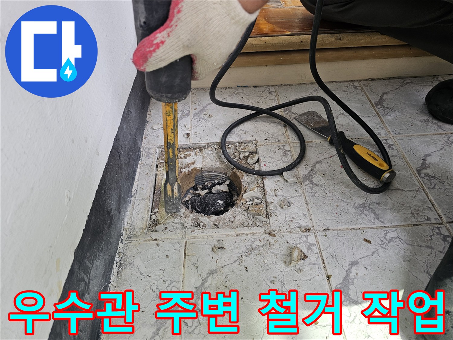 함마드릴을 사용하여-우수관 주변 타일과 시멘트를 제거하는 모습