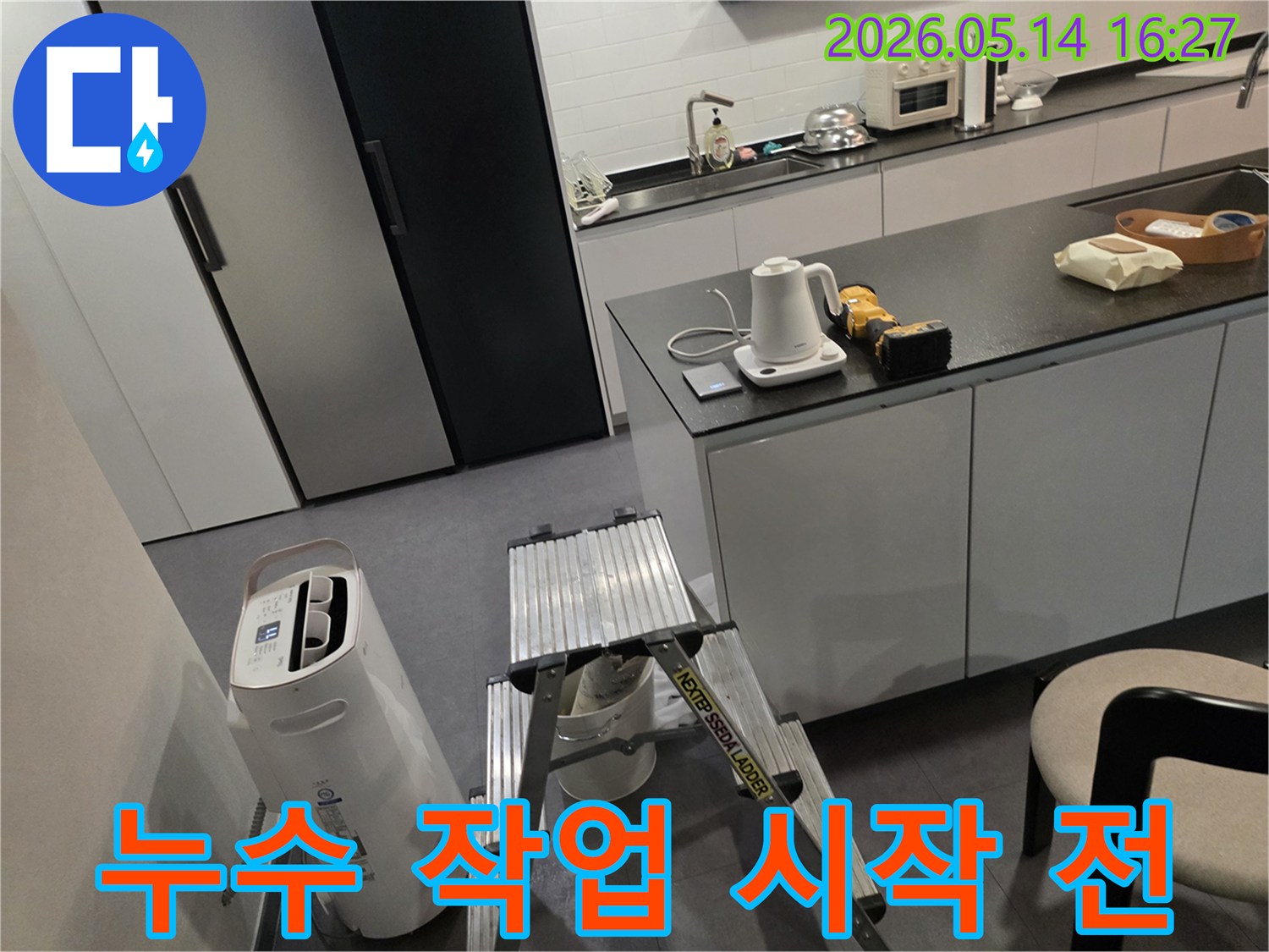 누수 탐지 전문가가-고객님의 주방에서-작업 전-장비 점검과-환경 확인을 하고 있습니다.