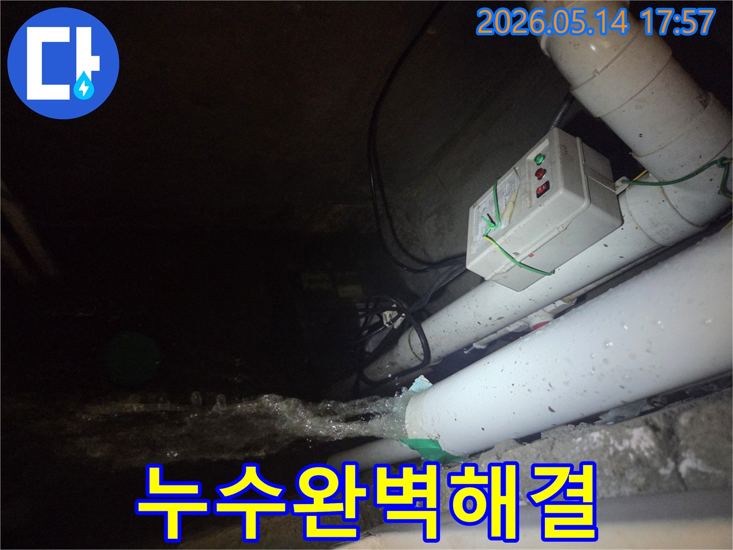 어두운 지하 공간에서-파이프에서 물이 강하게 뿜어져 나오는-누수 현장을 보여주는 사진입니다-전기 제어 박스와 배관들이 함께 보입니다.