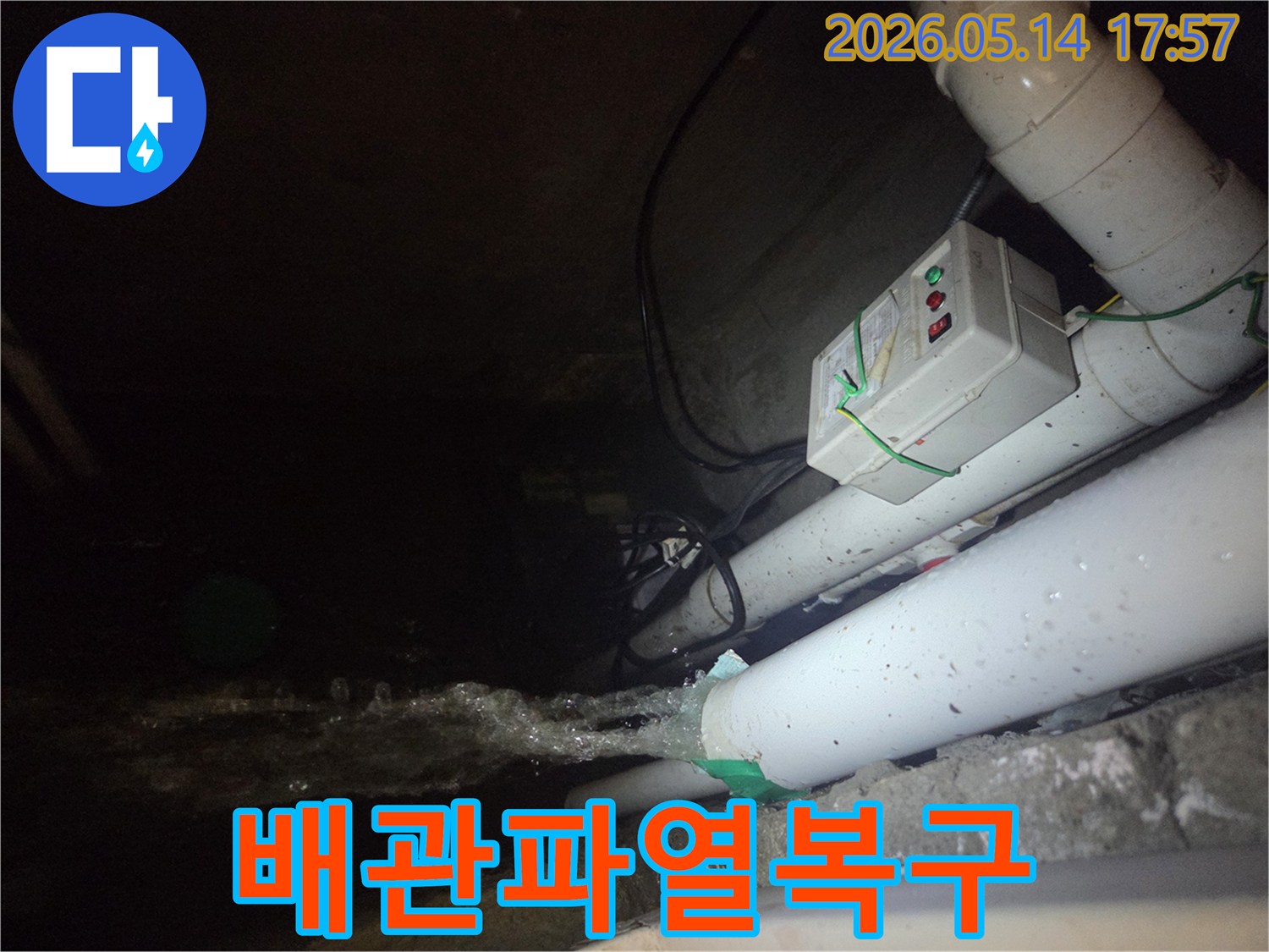 어두운 지하 공간에서-파이프에서 물이 강하게 뿜어져 나오는-배관 파열 누수 현장을 보여주는 사진입니다-전기 제어 박스와 배관들이 함께 보입니다.