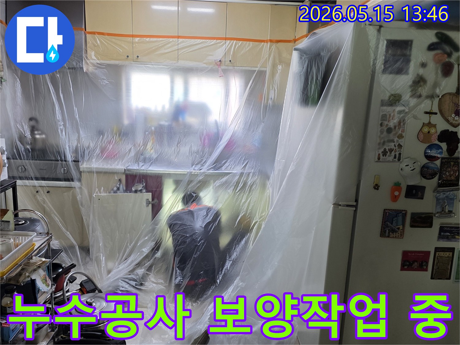 전문가가 주방에서-누수 공사를 위한-보양 작업을-꼼꼼히 진행하는 장면