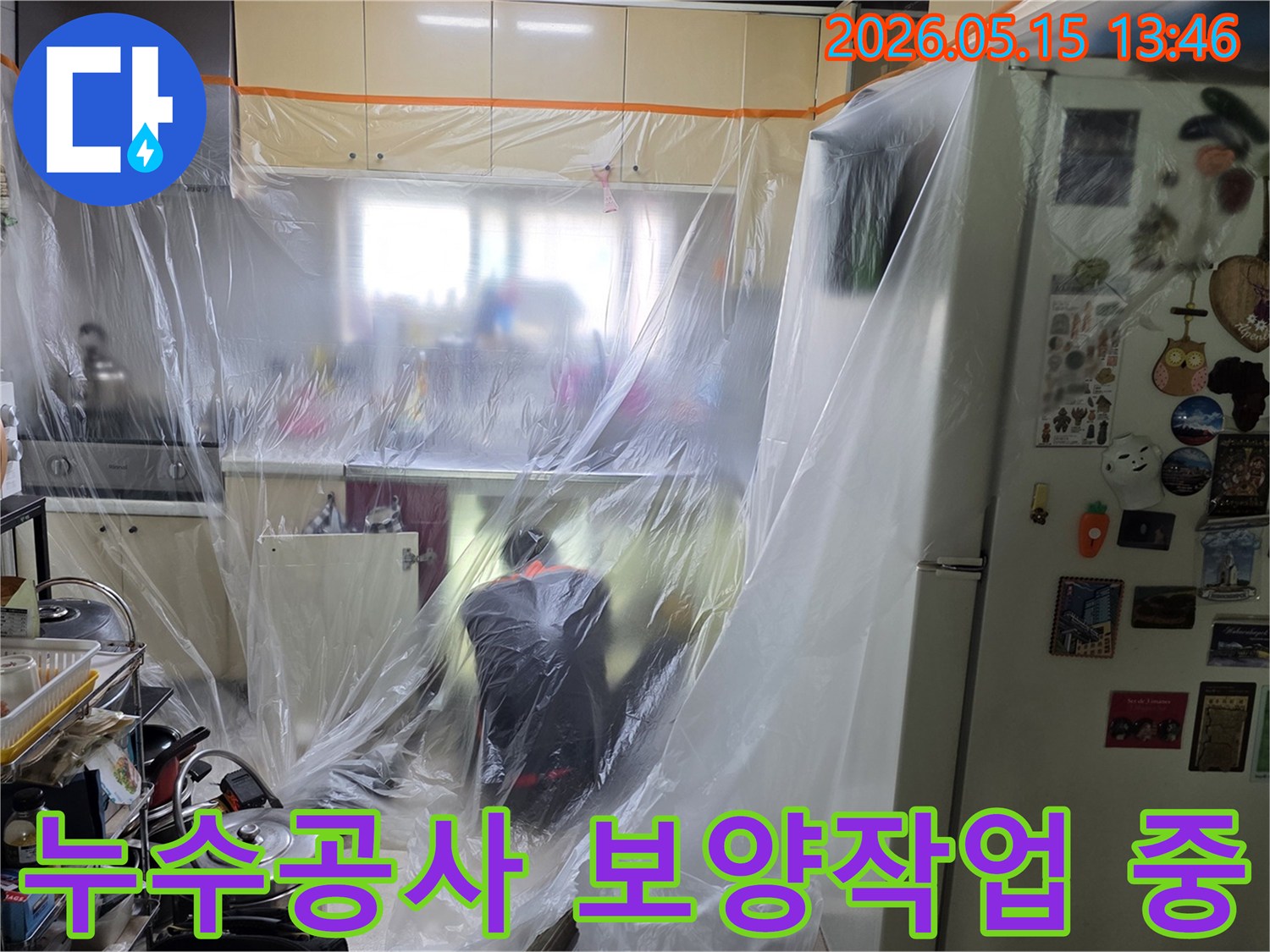 전문가가 주방에서-누수 공사를 위한-보양 작업을-꼼꼼히 진행하는 장면