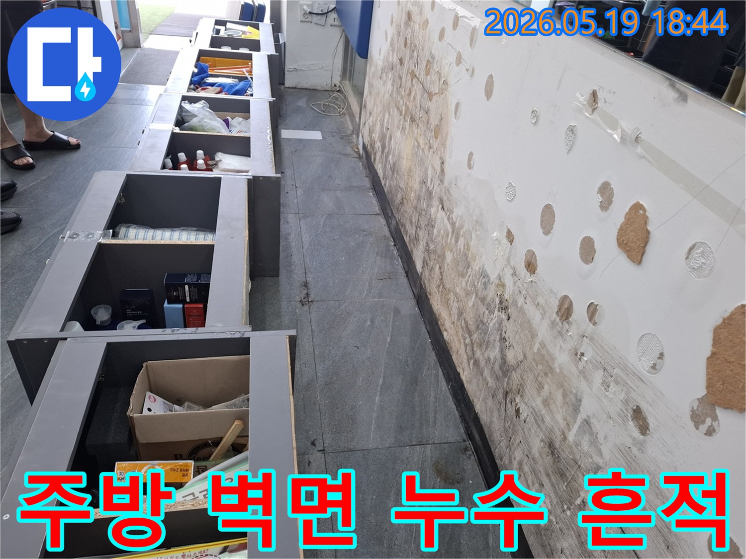 주방 싱크대 하부 벽면에서 발생한 누수로 인해-벽지가 젖고 곰팡이가 번식한 현장 사진