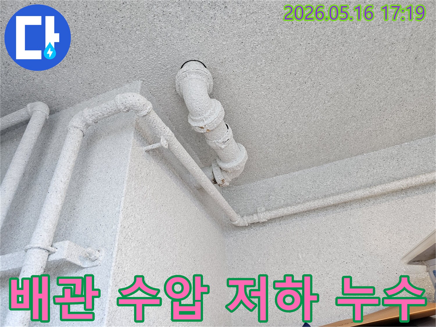 수원 장안구의 건물 천장에서-오래된 배관의 상태를 확인하며-수압 저하와 누수 간의 연관성을-고객에게 설명하는-누수 전문가의 모습