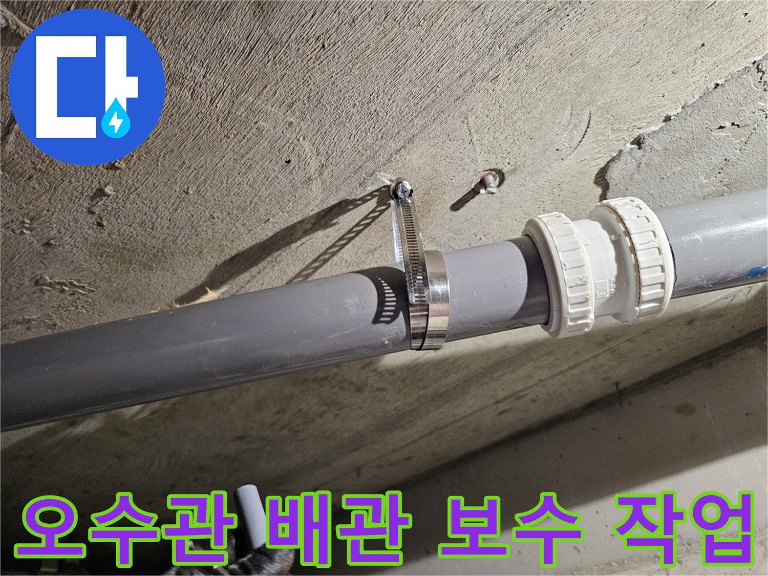 콘크리트 천장에 고정된 오수관과 금속 클램프 시공 상태