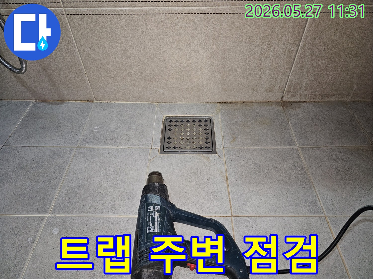 누수 엔지니어가-욕실 배수구 트랩 주변의-누수 여부를 확인하기 위해-열풍기로 건조하고 있습니다