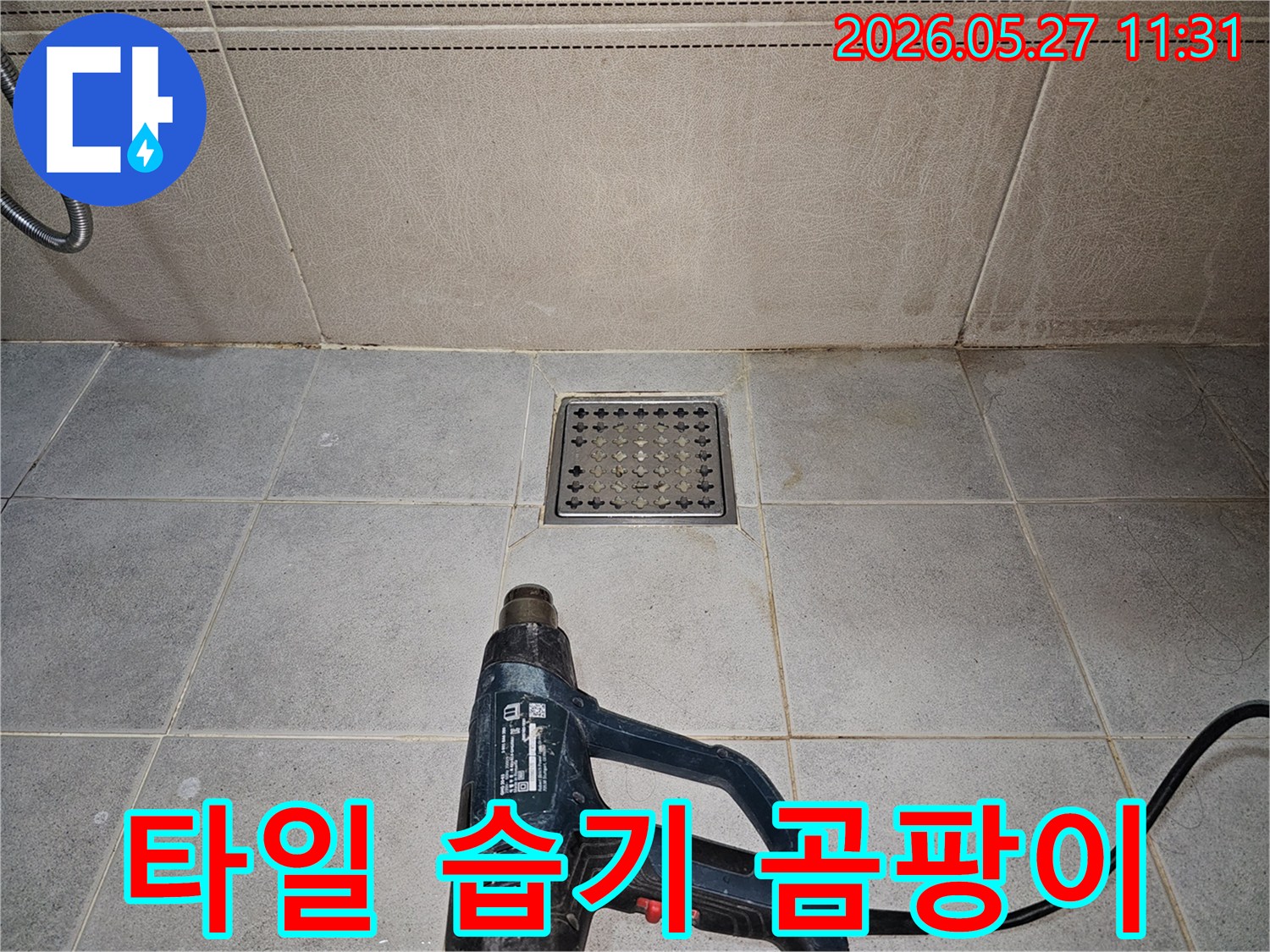 누수 엔지니어가-욕실 타일 아래의-습기를 열풍기로 제거하여-곰팡이 발생을 예방하고 있습니다