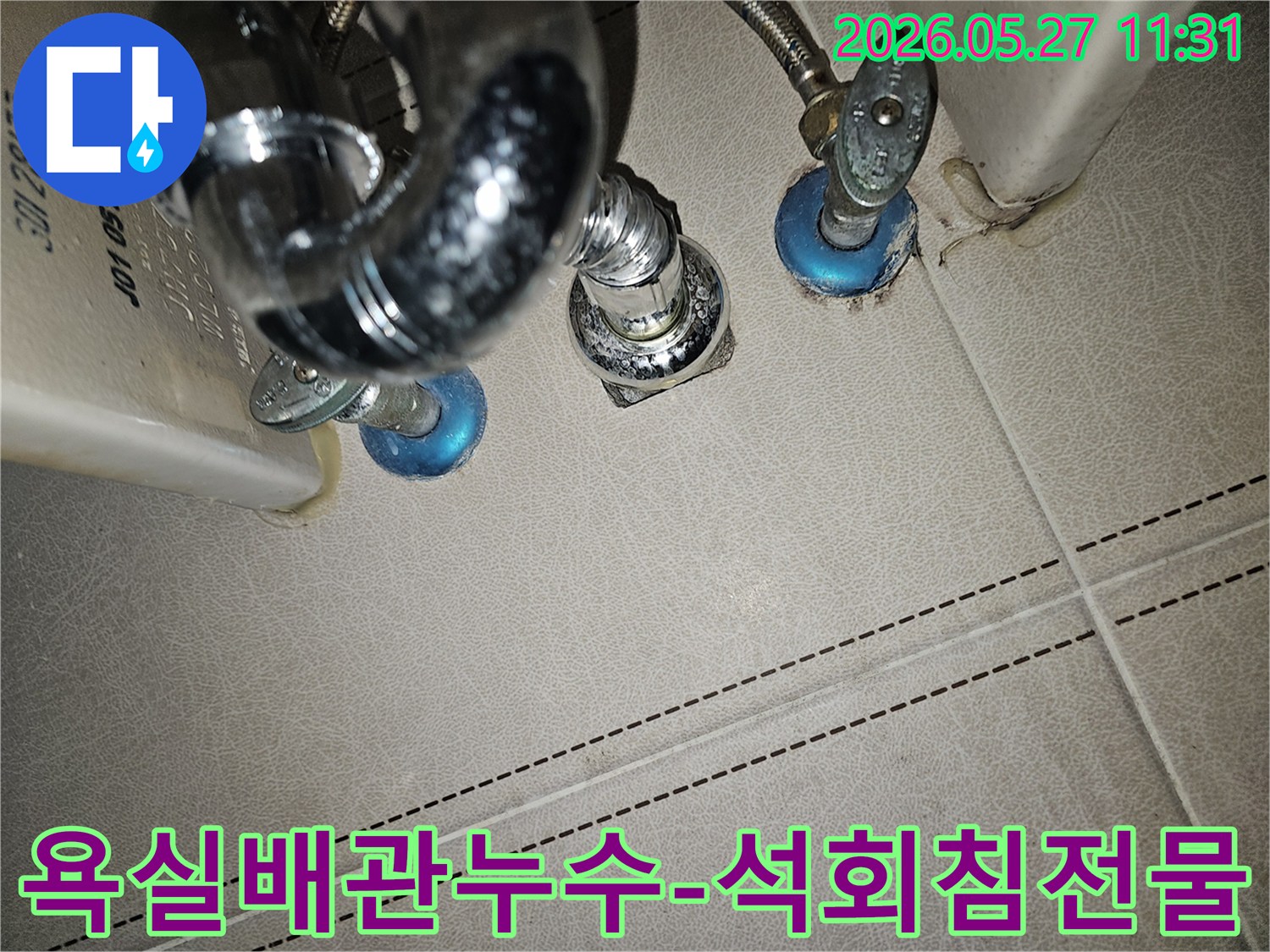 욕실 하부 배관에서-발견된-물방울과-하얀 석회 침전물로-누수가 의심되는-상황을 보여주는-이미지입니다