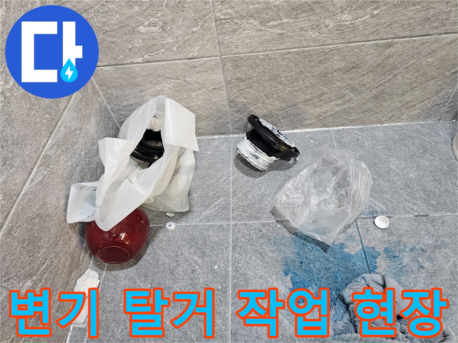 변기를 제거하고 드러난 오수관 주변의 물자국과 자재들