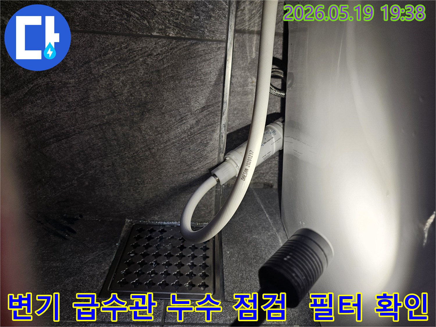이 이미지는-용인 수지 아파트 욕실에서-변기 급수관의 누수 여부를-플래시로 비춰가며-세밀하게 점검하는 장면입니다.