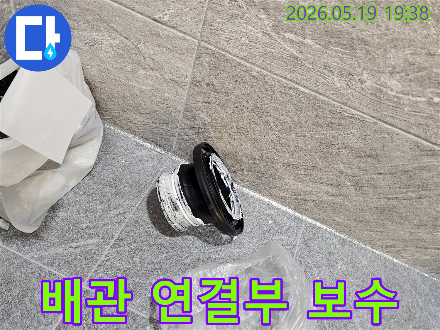 타일 아래 배관 수리 작업 중-누수 원인 부속을 제거하고-깔끔한 마무리를 위한 준비를 하고 있습니다.