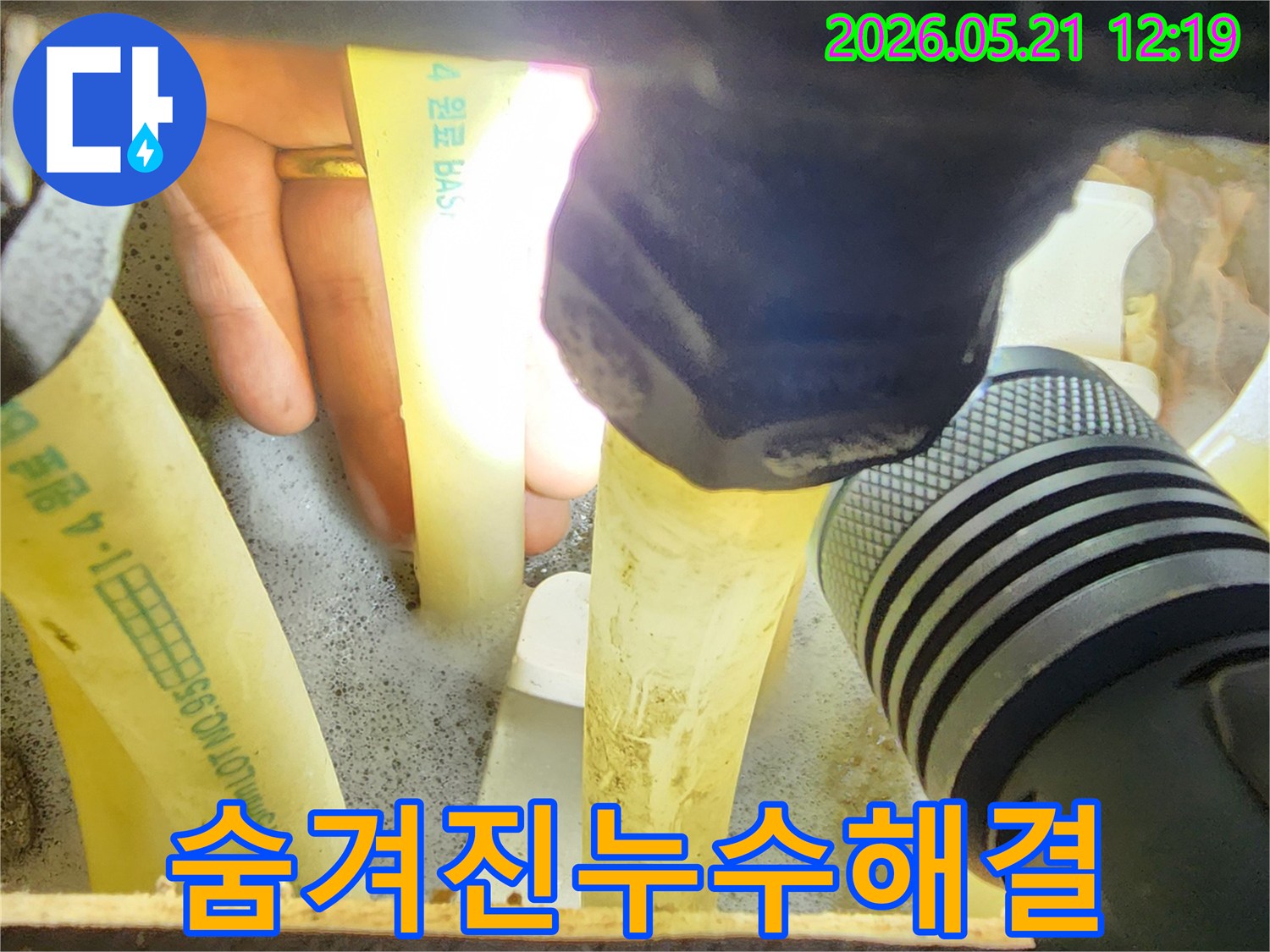 누수-엔지니어가-손전등으로-어두운-배관-틈새를-정밀하게-살펴보며-숨겨진-누수-지점을-찾아내는-모습