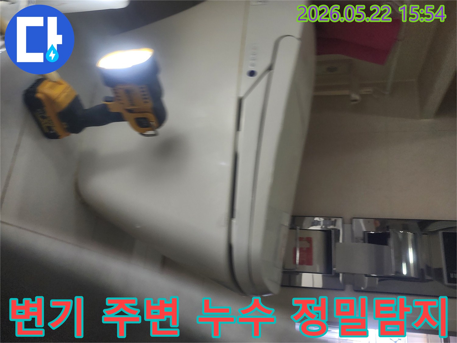 용인 보정동 화장실에서-변기 주변의 누수 여부를-정밀하게 탐지하기 위해-작업등을 비추며-세심하게 점검하는-누수 전문가의 현장 작업