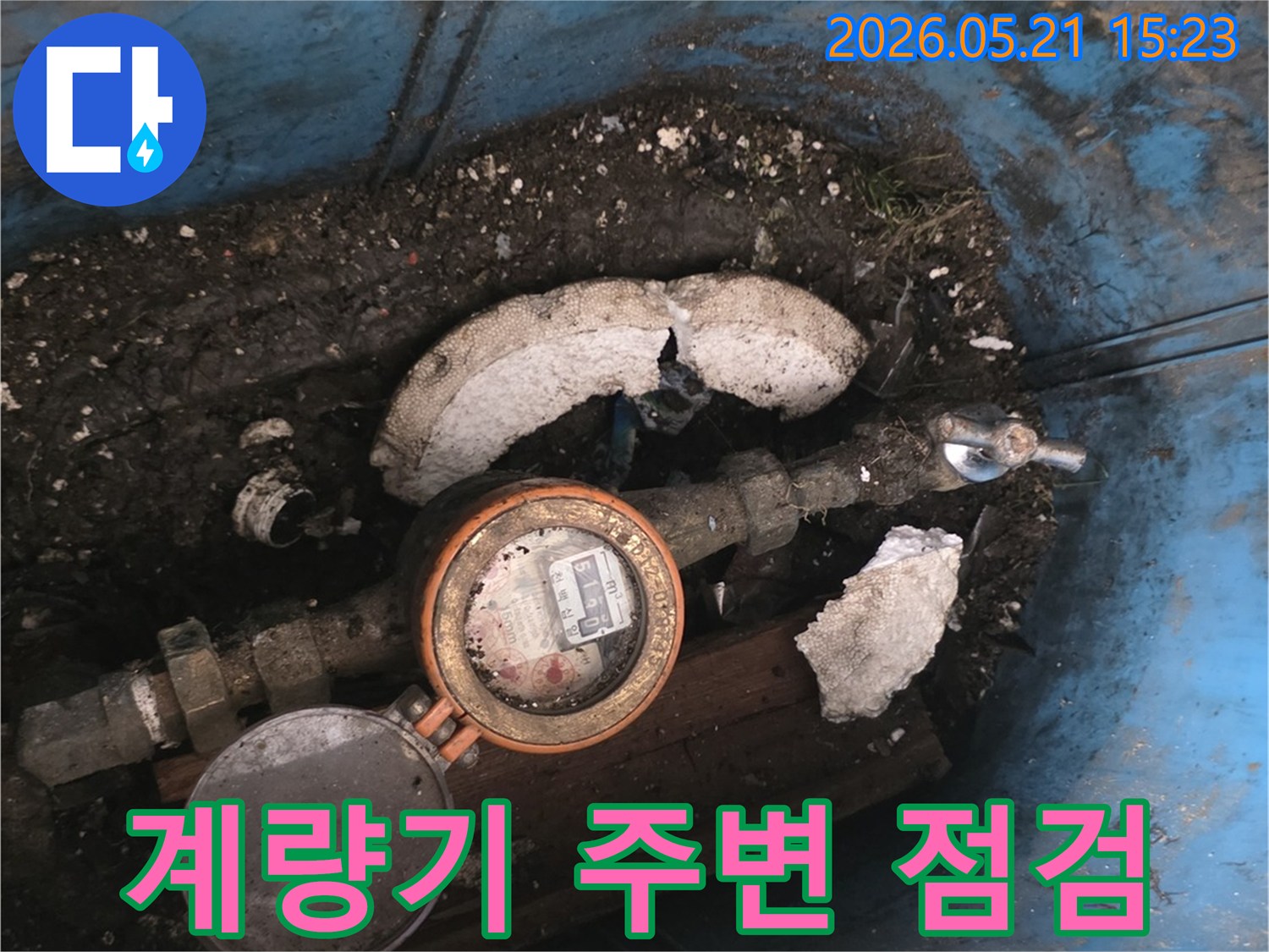 오래된-수도계량기가-설치된-지하 공간에서-누수 여부를-점검하는-모습을-담은-사진